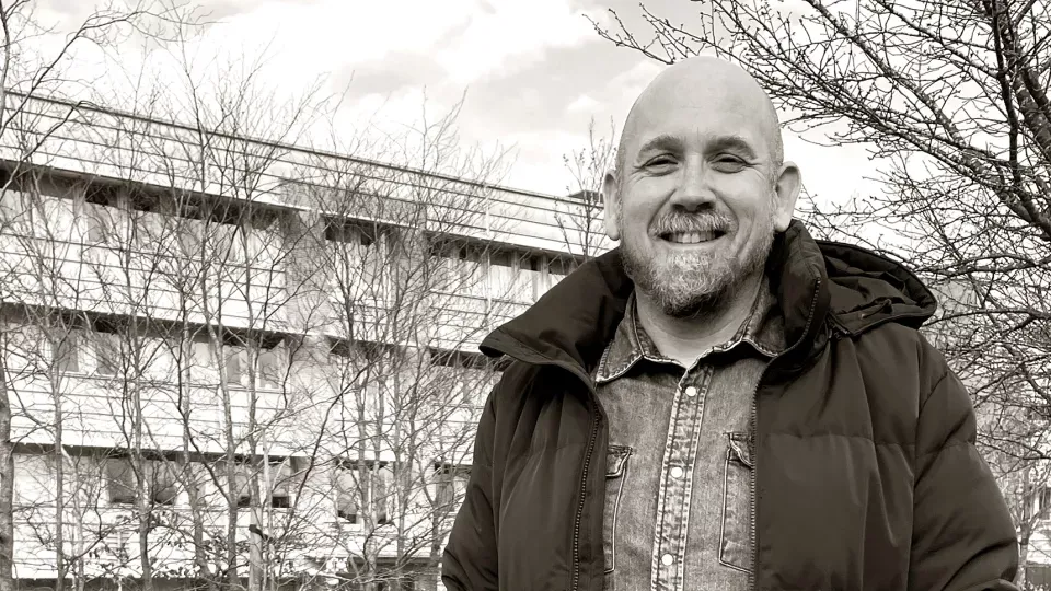 Stephan Schaefer ler mot kameran. Svartvitt foto.