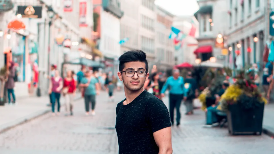 Man står på shoppinggatan. Foto.