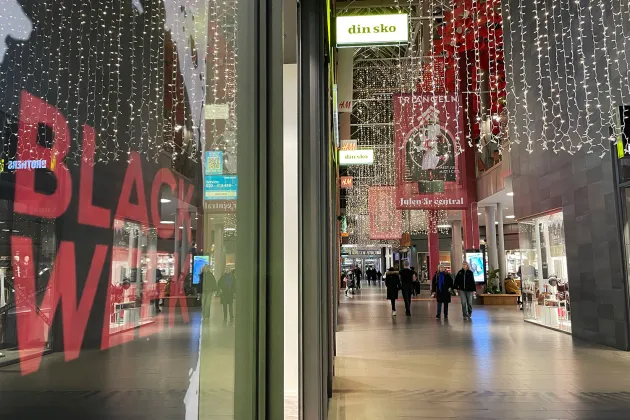 Interiör från ett shoppingcenter. I bild syns ett nästan folktomt golv och en affisch som det står "Black week" på. Foto.