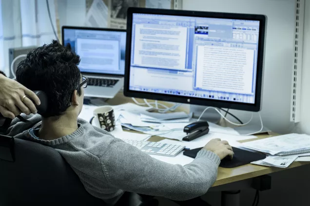Forskare sitter framför två datorskärmar.
