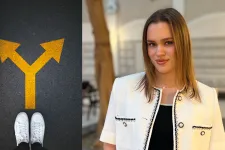 Ung kvinna står i ett atrium framför ett träd. Foto. 