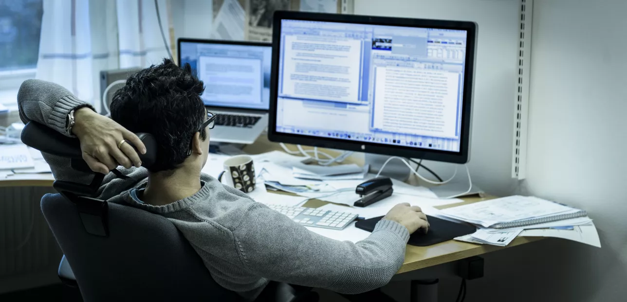 Forskare sitter framför två datorskärmar.